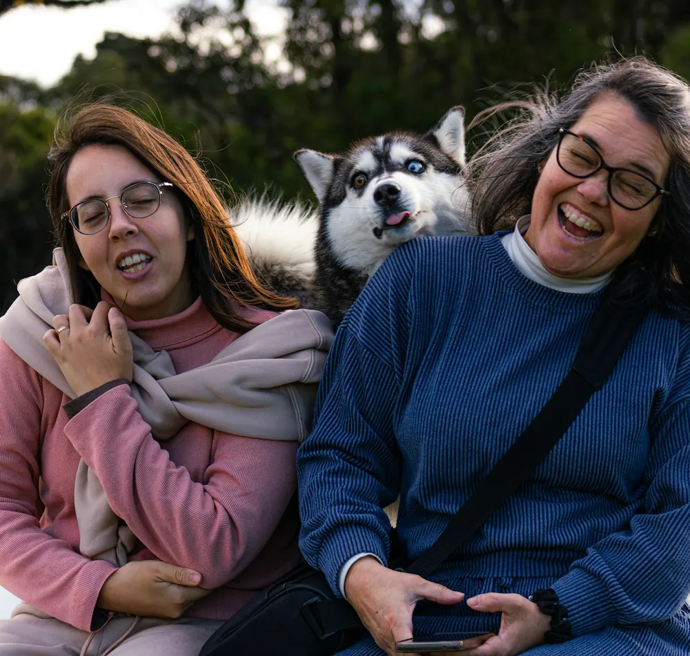 Deux femmes souriantes posent avec leur husky